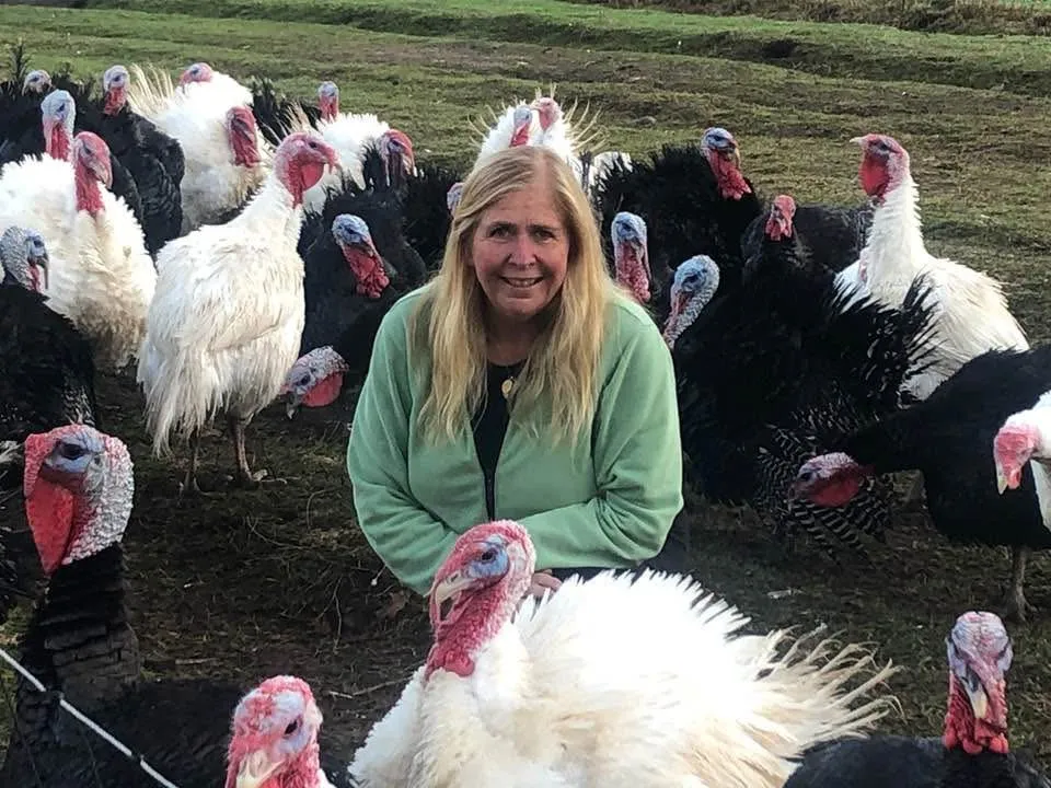 Shelley Gray surrounded by pasture-raised turkeys at Gray Family Farm